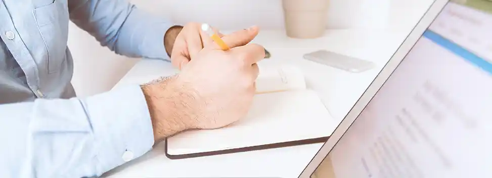 Mann vor Computer recherchiert.